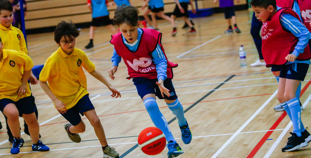 Children playing basket ball in a gym