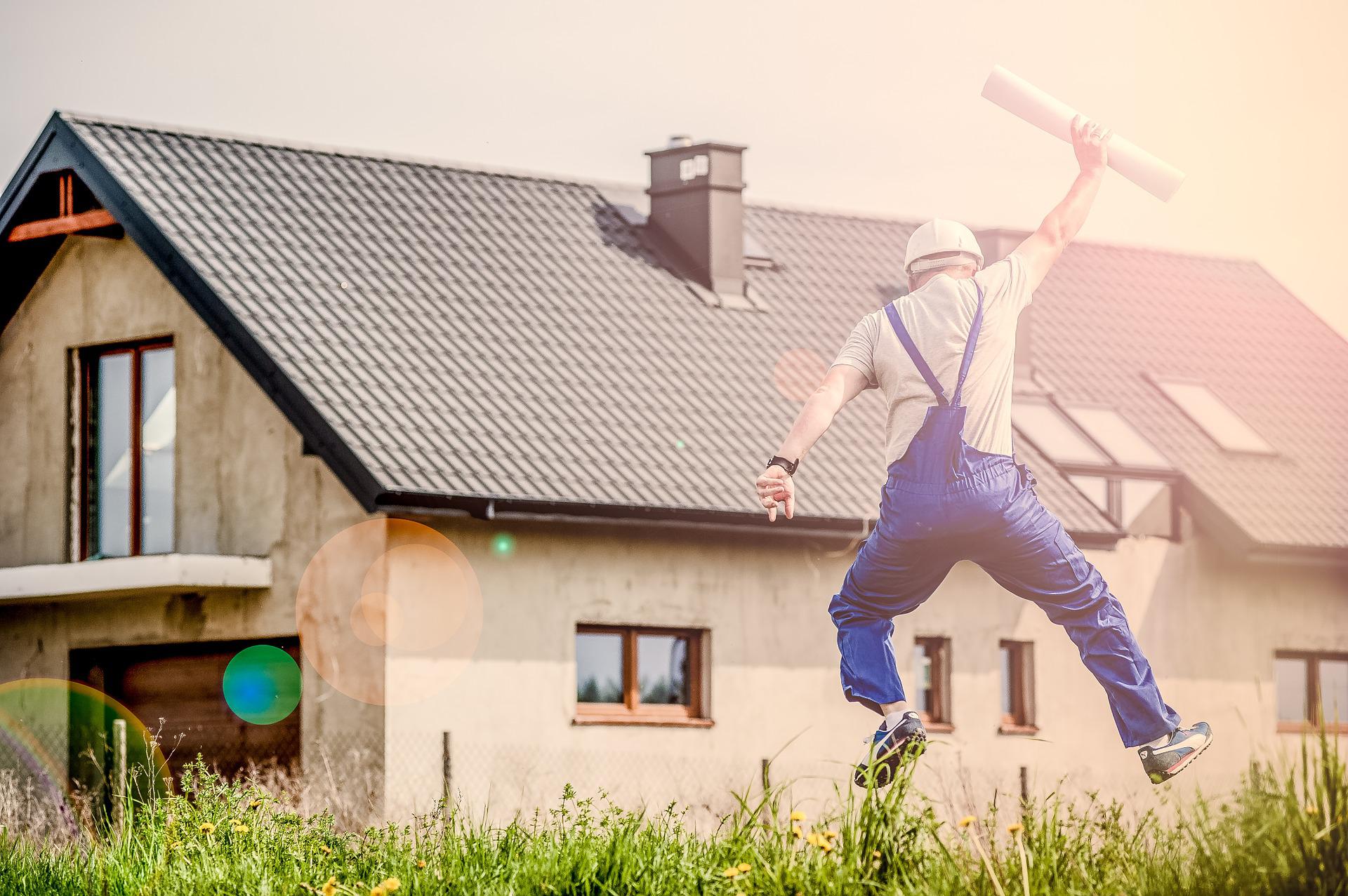 Architect jumping outside a house