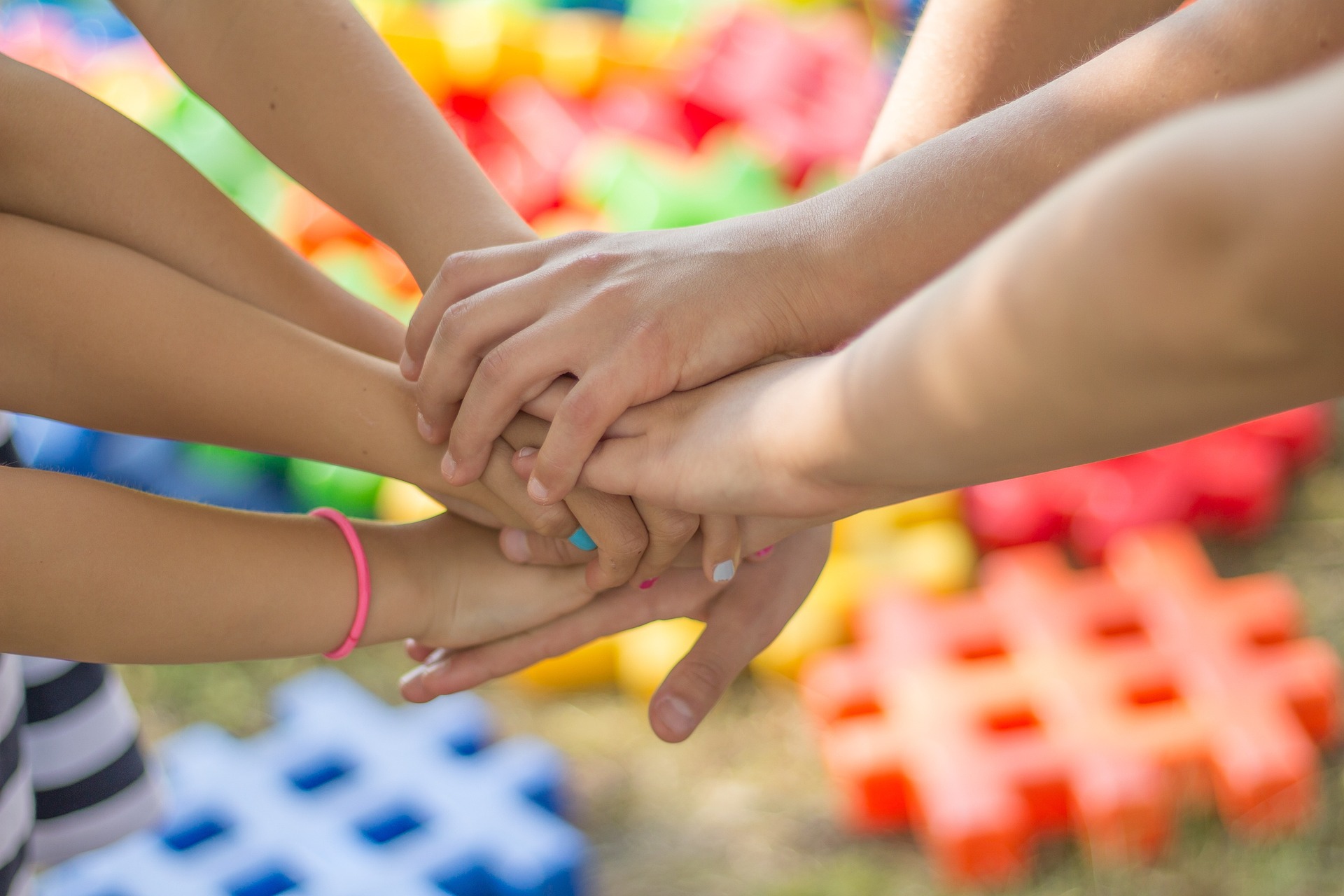 young people putting their hands in - one hand on top of the other