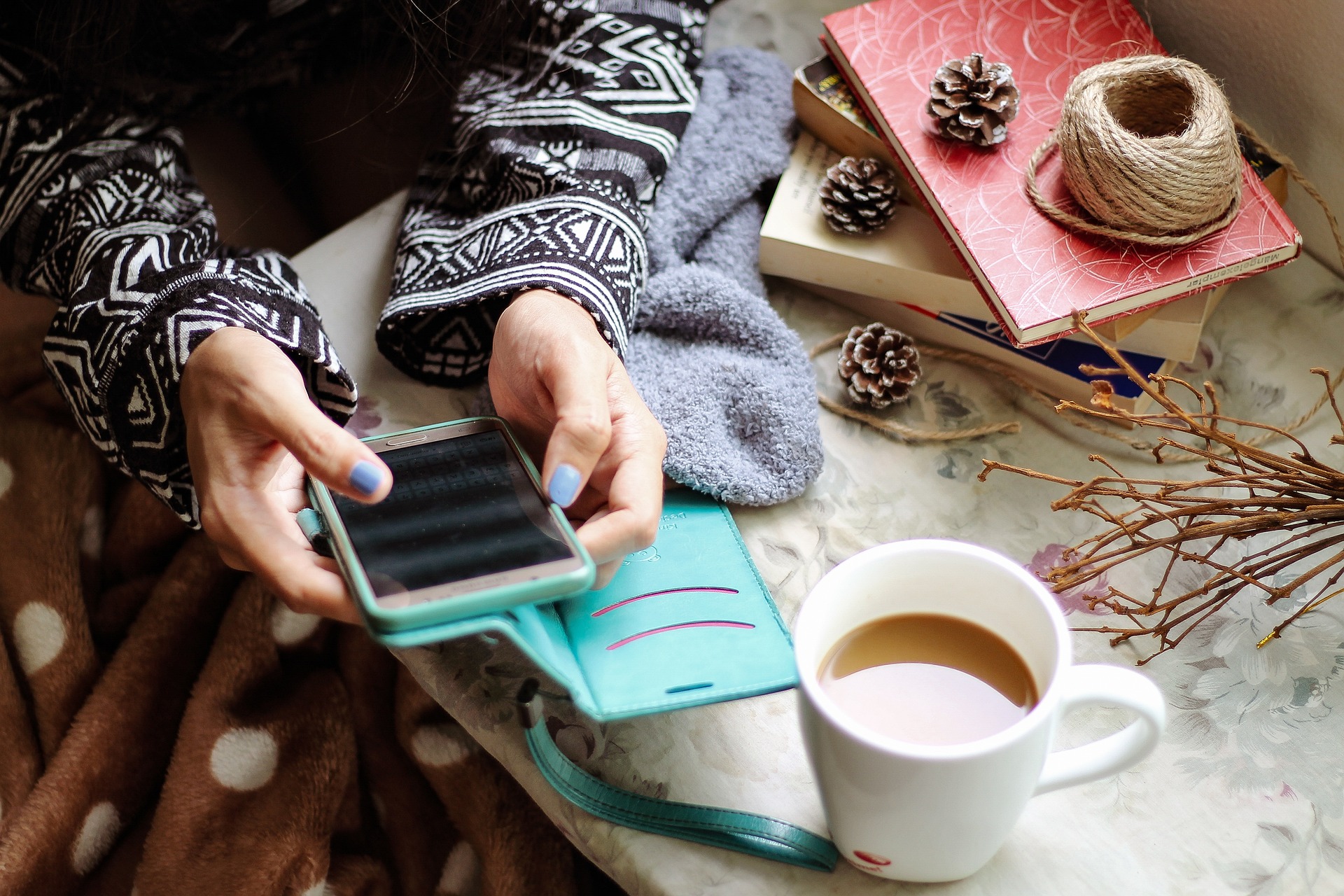 woman on phone with a mug of coffee