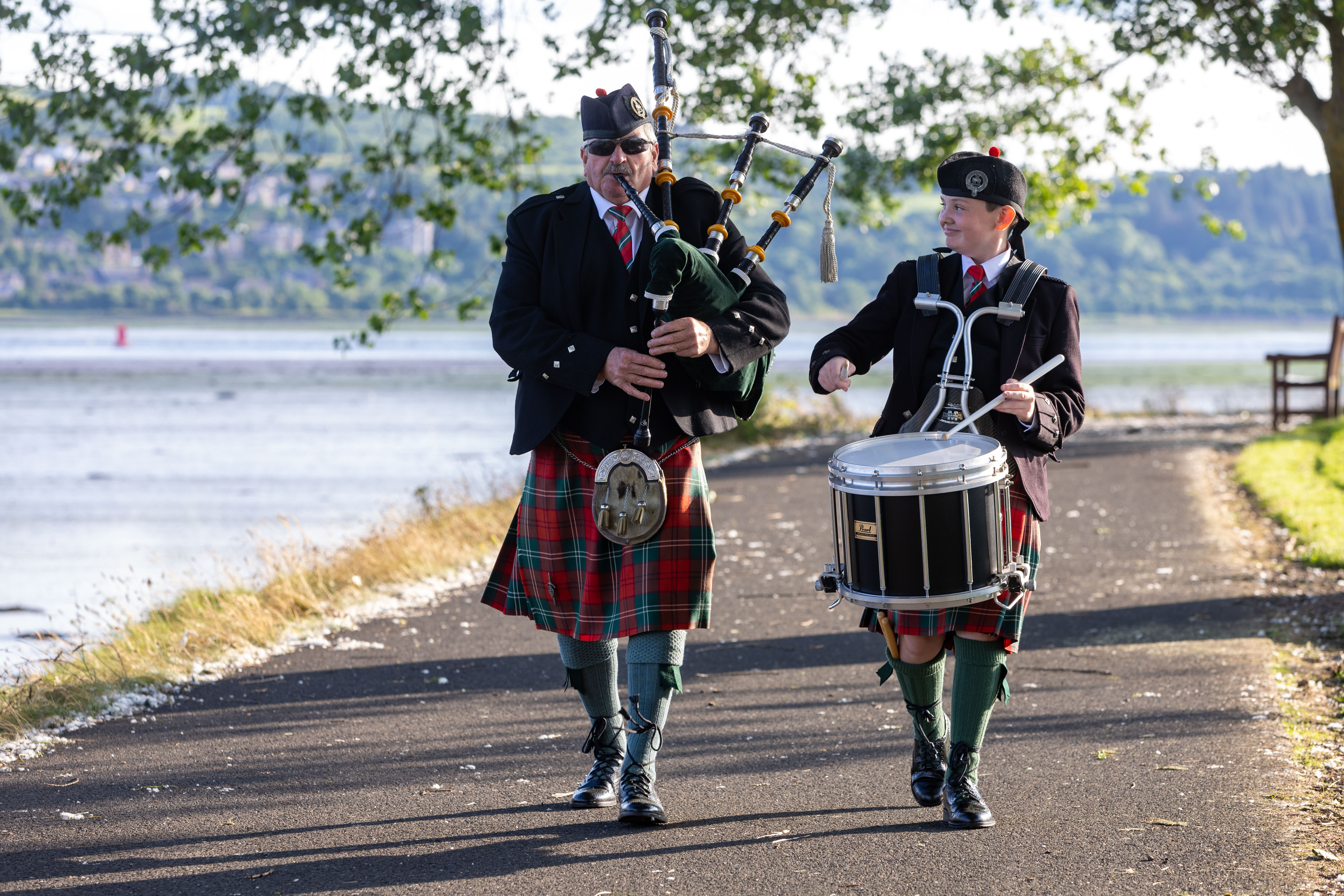 Piper Tam Gray and Drummer Alexander Brown walk along a path at Levengrove Park 