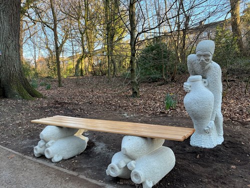 Roman bench with Roman figure behind lifting a jug