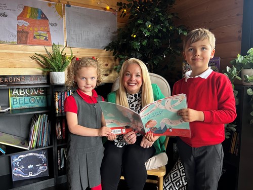 Cllr Steel reading with 2 young people